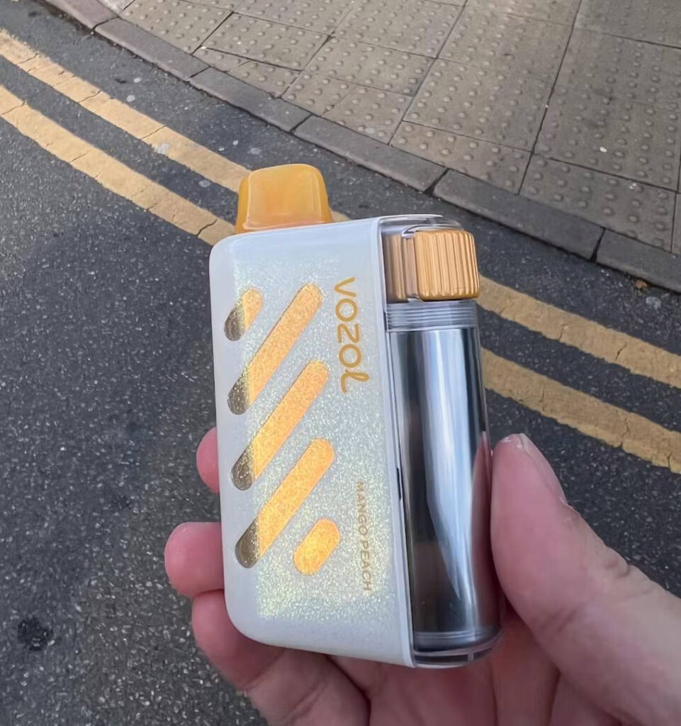 una mano che tiene un mango peach sapore vozol vista 40000