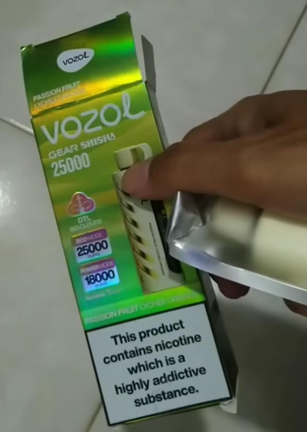 imagem em grande plano de uma pessoa a segurar a caixa de embalagem oficial vozol gear shisha 25000 para venda a retalho
