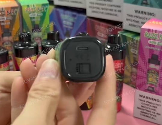 Hand, die das Modell razz bar 40k hält, um den unteren USB-C-Schnellladeanschluss und die Konstruktion des Sockels zu zeigen