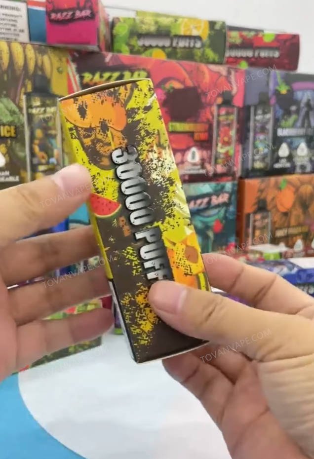 hand holding the front retail packaging box of the razz bar 30000